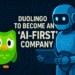 Η Duolingo ανακοίνωσε τη μετάβασή της σε μια «AI-first» στρατηγική, αντικαθιστώντας εξωτερικούς συνεργάτες, όπως μεταφραστές και συντάκτες, με τεχνητή νοημοσύνη. Ο δημοσιογράφος Brian Merchant επισημαίνει ότι η τάση αυτή είχε ξεκινήσει ήδη από το 2023 και συνδέεται με μια ευρύτερη κρίση θέσεων εργασίας, ιδιαίτερα σε δημιουργικούς τομείς. Η κρίση αυτή δεν εκδηλώνεται με θεαματικά τεχνολογικά σενάρια, αλλά μέσω διοικητικών αποφάσεων για μείωση κόστους και περιορισμό προσλήψεων, κυρίως σε αρχικού επιπέδου θέσεις και ελεύθερα επαγγέλματα.