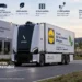 Η Lidl δοκιμάζει στη Γερμανία το μέλλον των εμπορευματικών μεταφορών, εντάσσοντας στις καθημερινές παραδόσεις της ένα ηλεκτρικό, αυτόνομο φορτηγό Level 4 της Einride. Το όχημα κινείται σε δημόσιους δρόμους χωρίς οδηγό ή χειριστή ασφαλείας στην καμπίνα και μπορεί να πραγματοποιεί έως τρία δρομολόγια την ημέρα. Το πιλοτικό πρόγραμμα θα διαρκέσει τέσσερις μήνες και θα βοηθήσει τη Lidl να αξιολογήσει κατά πόσο η αυτόνομη οδήγηση μπορεί να ενσωματωθεί σε μεγαλύτερη κλίμακα στο δίκτυο logistics της.